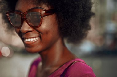 Güzel afro-amerikan bayan kameraya bakarak ve gülümseyerek