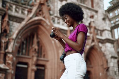 Afro-Amerikalı bayan kamera ile sokakta duruyor