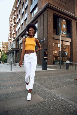 Sokakta günün tadını çıkarırken gözlüklü gülümseyen afro-amerikalı kadın