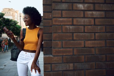 Şehirde yürüyen mutlu genç afro-Amerikan bayan