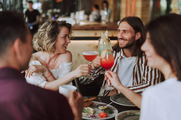 Fröhliche Freunde, die mit Cocktails anstoßen, während sie Zeit im Café verbringen — Stockfoto