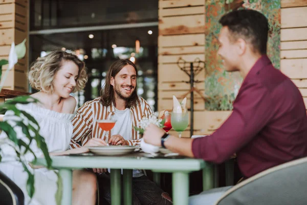 Három barát csevegni és nevetve a hangulatos kávézóban — Stock Fotó