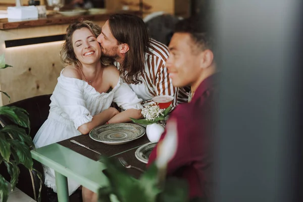 Junger Mann küsst seine charmante Freundin im Café — Stockfoto