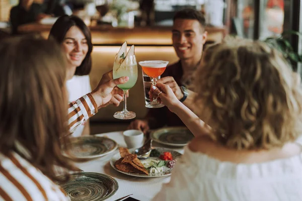 Glada vänner rosta med cocktails samtidigt tillbringa tid i kaféet — Stockfoto