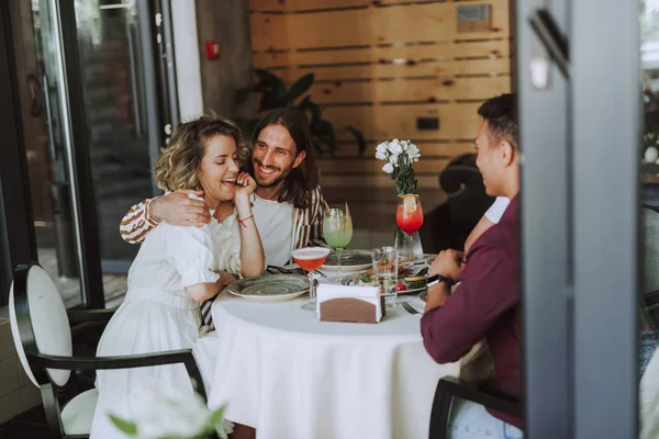 Wesoła przyjaciele rozmawiając, śmiejąc się i delektując się napojami w kawiarni — Zdjęcie stockowe