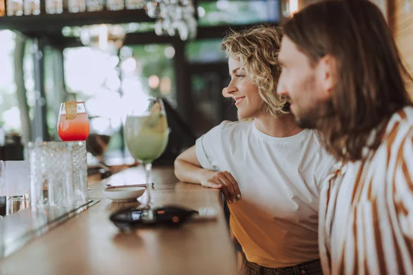 Piękna para siedząca na liczniku bar z koktajlami — Zdjęcie stockowe