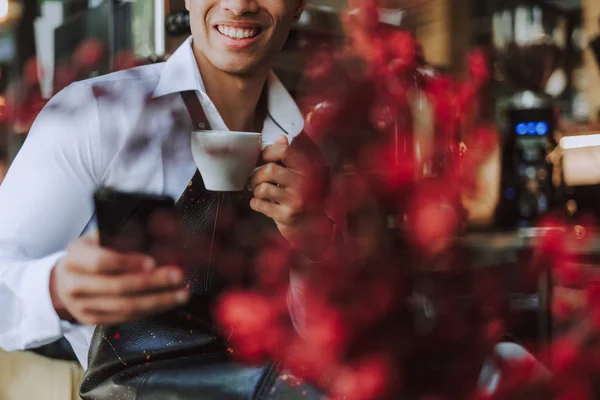 Vidám fiatalember csésze kávéval cellphone — Stock Fotó