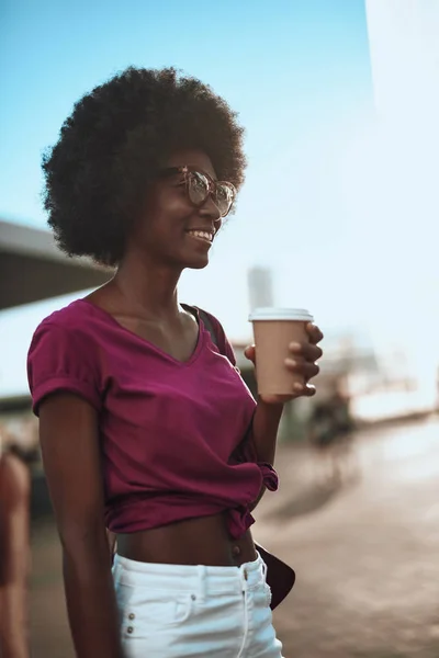 Sorridente donna afro-americana che si gode un caffè per strada — Foto Stock