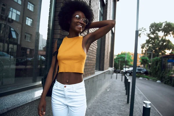 Sonriente bella dama en gafas caminando por la ciudad — Foto de Stock