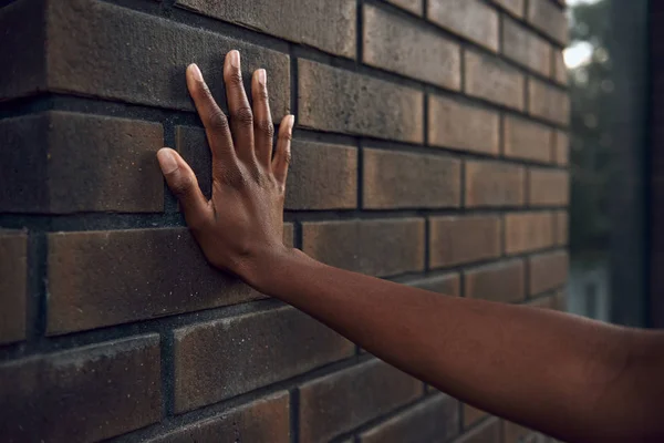 Frauenhand streift Ziegelmauer — Stockfoto