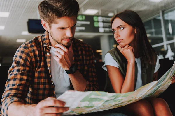 Pensativo hombre y mujer están planeando vacaciones en el aeropuerto — Foto de Stock