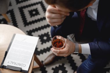 Yorgun işadamı sözleşme önünde oturuyor