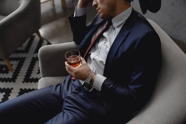 Hombre cansado en traje inclinando la cabeza y bebiendo alcohol — Foto de Stock