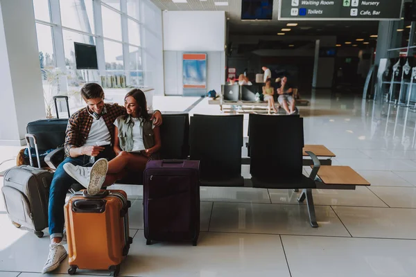 Усміхнена пара чекає на літак у приміщенні — стокове фото