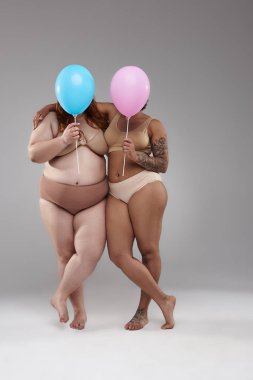 Artı boyutu kadın modelleri balonlar arkasında yüzleri gizleme