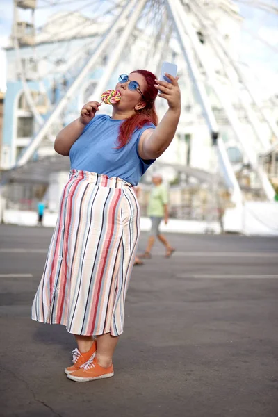 Νέα χοντρή γυναίκα κάνοντας selfie και τρώγοντας γλειφιτζούρι — Φωτογραφία Αρχείου