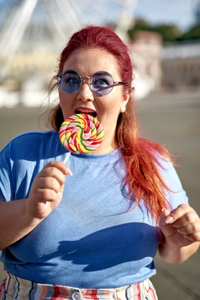 Vet en jonge vrouw eten Lollipop op straat — Stockfoto