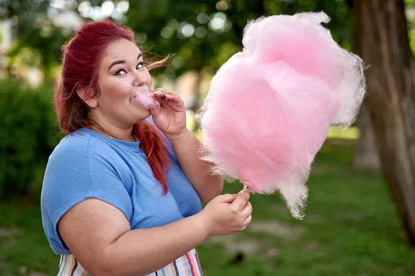 Şişman genç kadın şeker-diş ipi bulutu ile yürüyüş — Stok fotoğraf