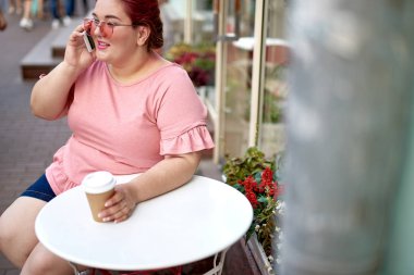 Akıllı telefonda konuşan genç ve şişman kadın