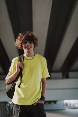 Sırt çantası taşıyan ve gülümseyen neşeli genç adam