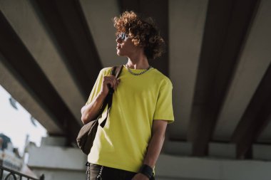 Sırt çantası ile Pensive genç adam uzağa bakıyor