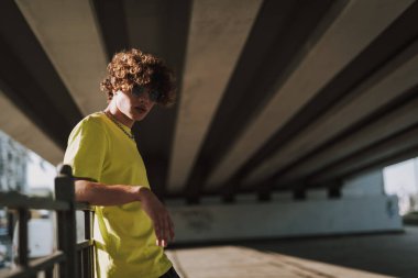 Sakin genç adam çit üzerine dirsek koyarak