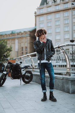 Genç bisikletçi sokakta sigara içiyor