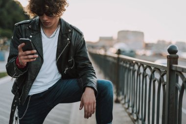 Kıvırcık ciddi adam gadget ekranına bakıyor