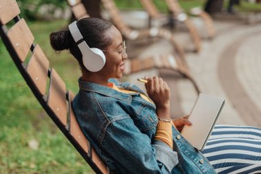 Genç afro-amerikalı kadın not defterine metin yazma