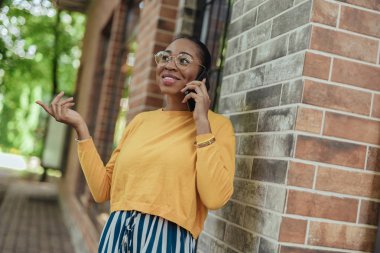 Akıllı telefonda konuşan gülümseyen afro-Amerikan bayan