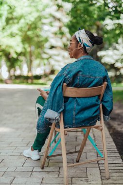 Kafenin dışındaki terasta oturan Afro-amerikalı bayan