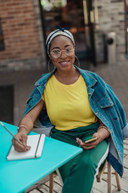 Mutlu afrikalı amerikalı bayan not defterine notlar yazma