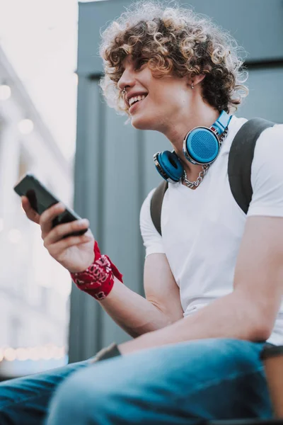 Estudiante alegre con smartphone al aire libre sonriendo felizmente — Foto de Stock