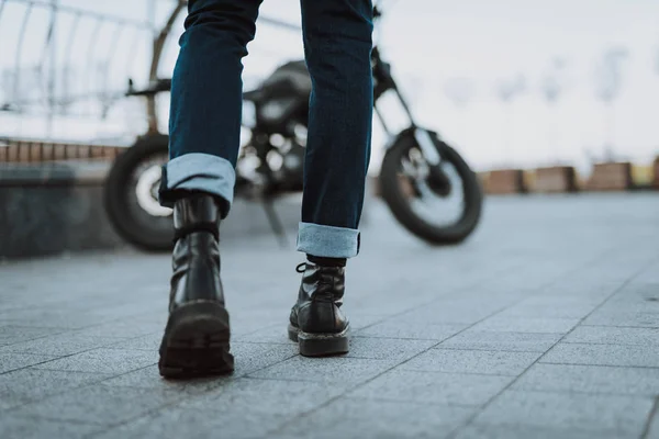 Beine einer Person in Jeans und Lederstiefeln — Stockfoto