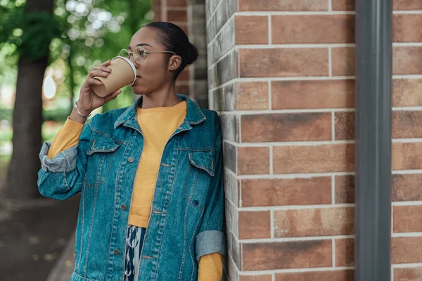 Mladá africká americká žena pije kávu ve městě — Stock fotografie