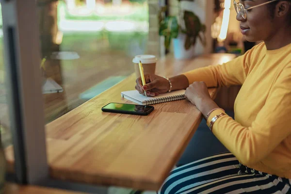 Jonge vrouw schrijven notities in papier Kladblok — Stockfoto