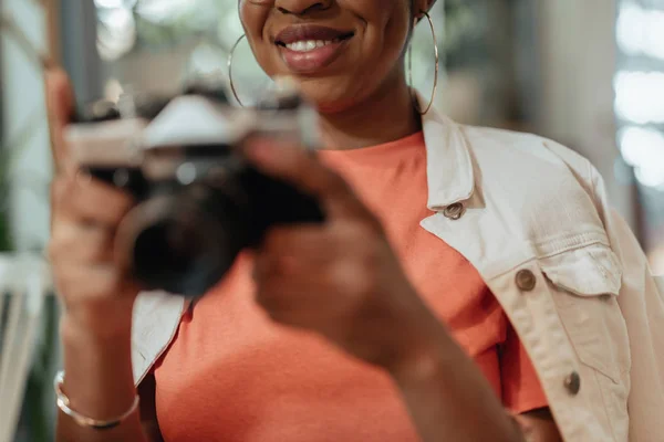 Lächelnde Afroamerikanerin hält Fotokamera in der Hand — Stockfoto