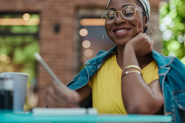 Usmívající se africká americká žena píše poznámky v poznámkovém bloku — Stock fotografie