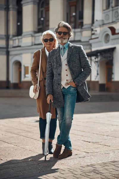 Sonriente hombre con paraguas de pie con esposa stock foto — Foto de Stock