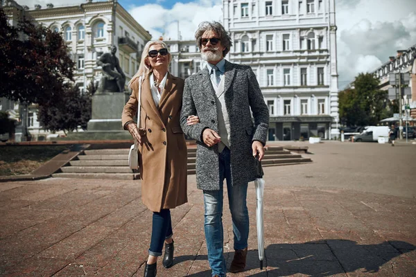 Bärtiger Mann mit Regenschirm spaziert mit Frau Archivfoto — Stockfoto