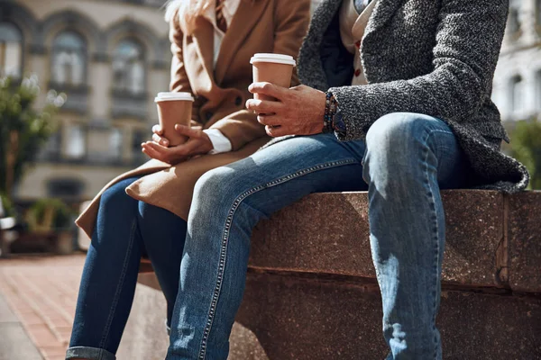 Para w dżinsy siedzi z filiżanek kawy Zdjęcie stockowe — Zdjęcie stockowe