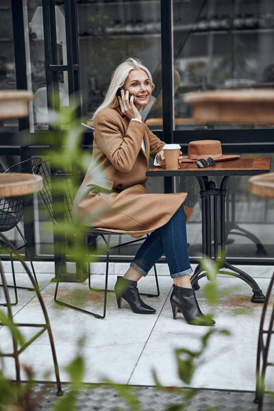 Smiling woman talking on the phone in cafe stock photo