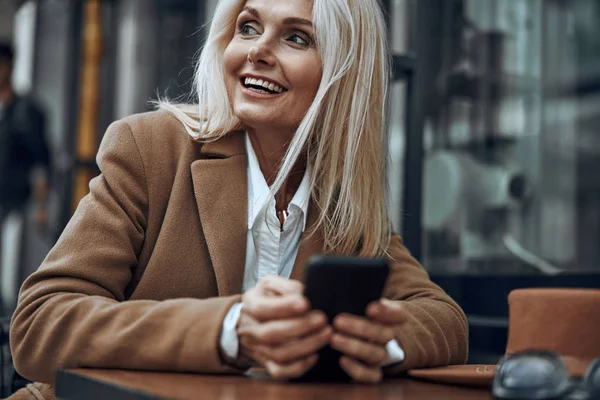 Счастливая женщина со смартфоном улыбается акции фото — стоковое фото