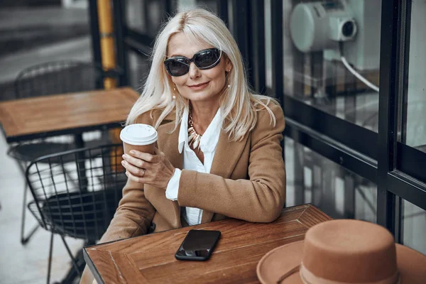 Señora adulta con café para ir buscando foto de stock contento —  Fotos de Stock