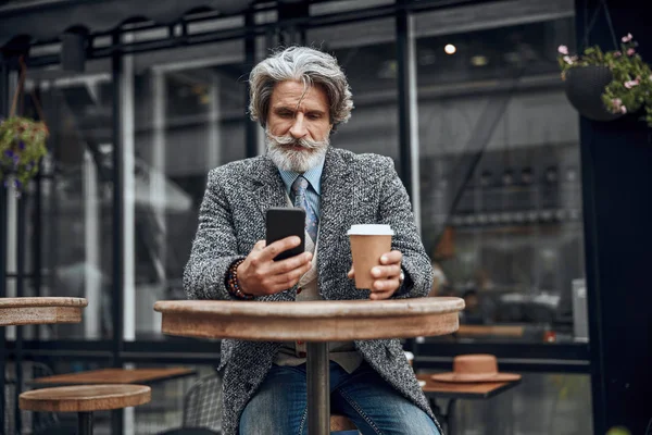 Homme avec smartphone à la haute table de café photo de stock — Photo