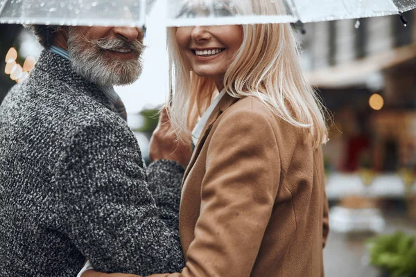 Sonriendo pareja bajo un paraguas juntos stock foto — Foto de Stock