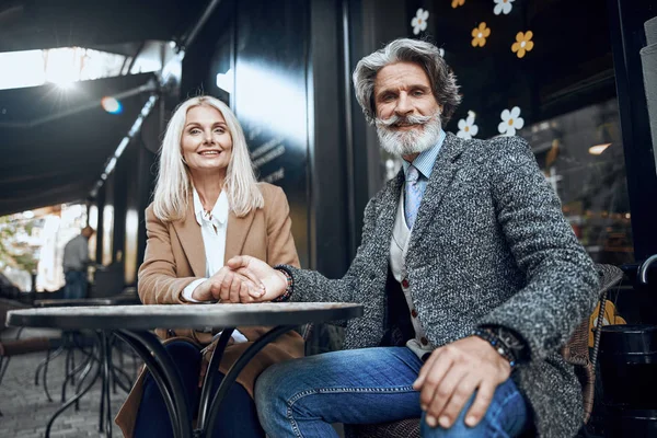 Любящие взрослые пары держатся за руки на фото в кафе — стоковое фото