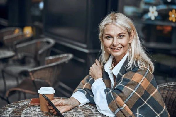 Mujer feliz con smartphone en la terraza de la cafetería —  Fotos de Stock