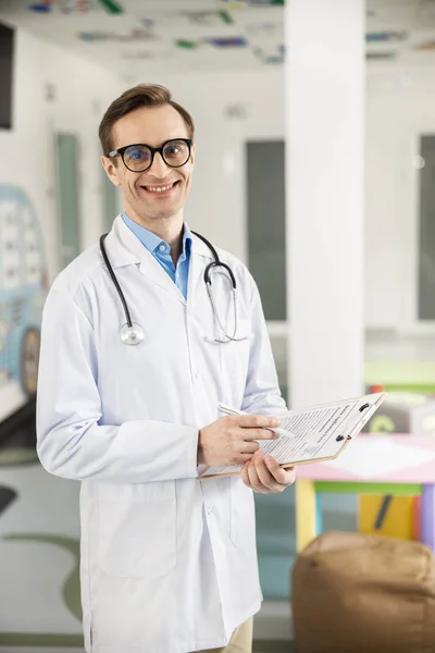 Alegre médico que trabaja en la clínica infantil foto de stock — Foto de Stock