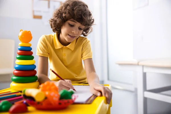 Cheerful boy is painting in hospital palyroom stock photo